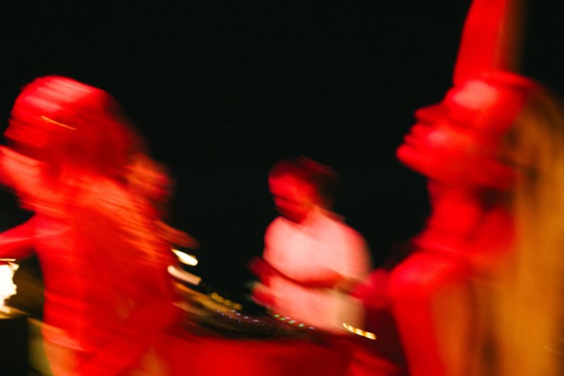 Dancers moving under red light at night