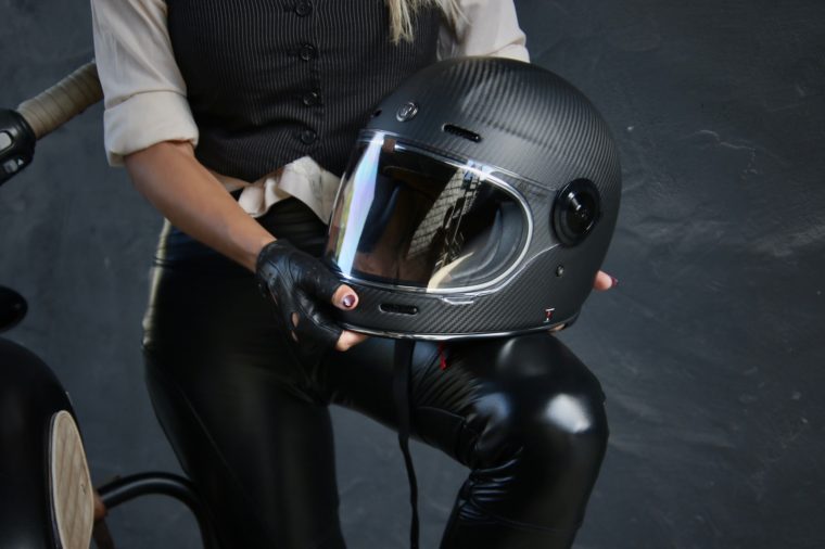 Aly holding a helmet beside the motorcycle