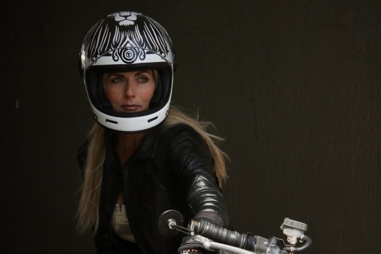 Aly in a white graphic helmet on the motorcycle