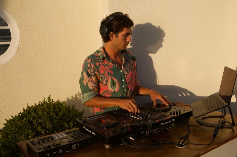 Scott Welch DJing at the Pioneer decks at golden hour in Laguna Beach